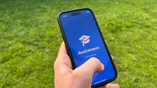 AuxCampus App in der Hand – iPhone mit geöffneter AuxCampus-App im Freien